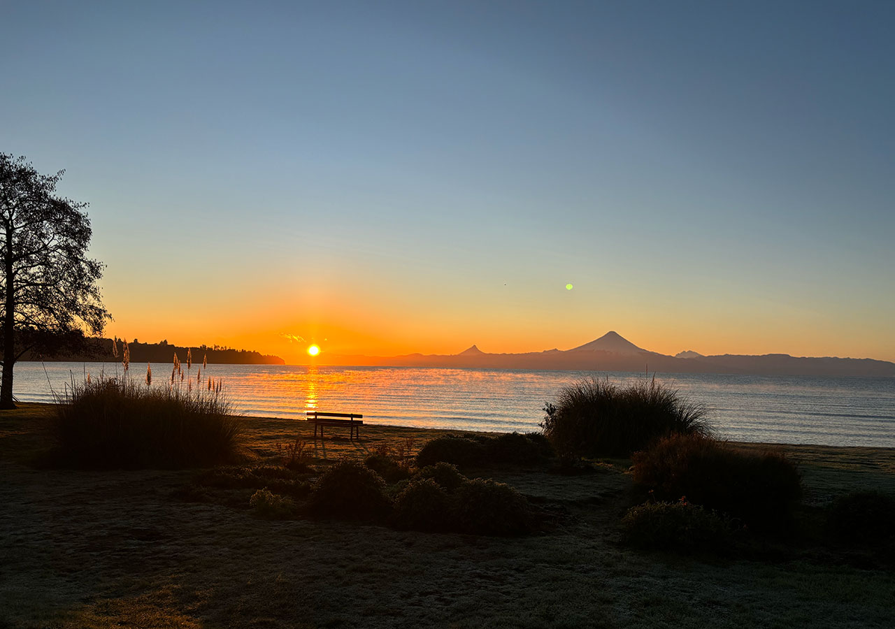 Amanecer sobre el lago Llanquihue con los volcanes en el horizonte