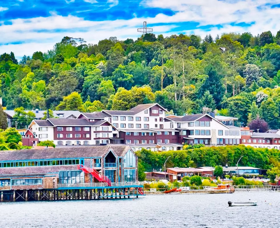 Costanera de Puerto Varas con hoteles, muelle de madera y cerro boscoso junto al lago Llanquihue